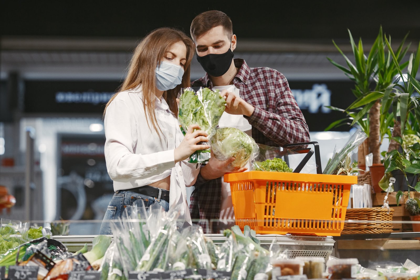 Covid-19 spreading outbreak. Couple in medical protective mask. Family walks in a supermarket.